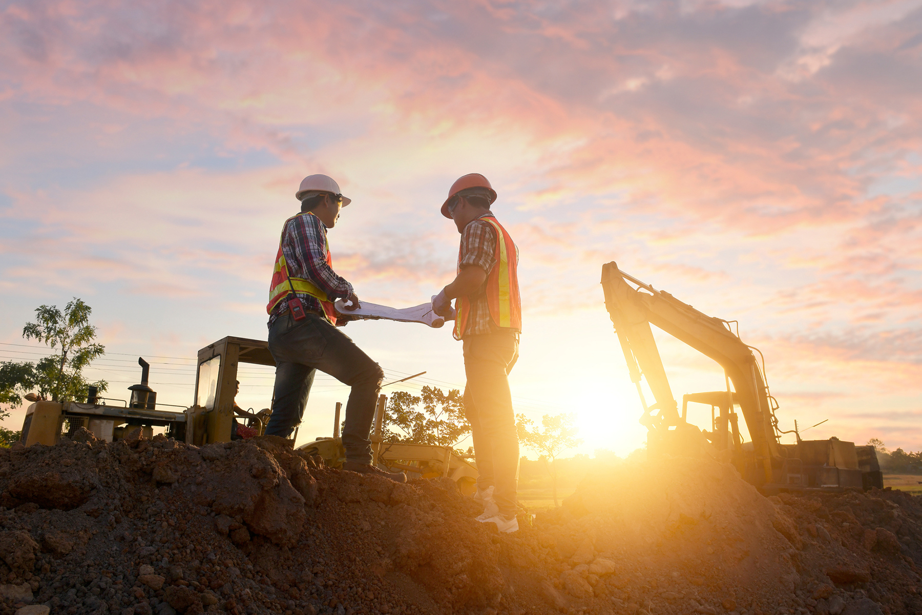 construction workers on site at sunset